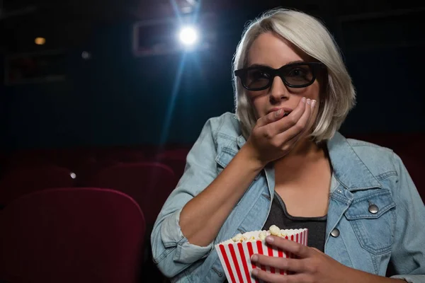 Женщина ест попкорн во время просмотра фильма — стоковое фото