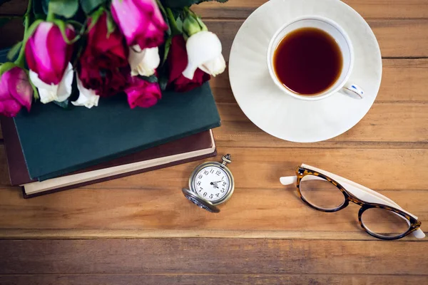Eyeglasses by stopwatch and tea with books — Stock Photo, Image