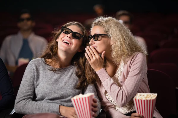 Amigos do sexo feminino fofocando enquanto assiste filme — Fotografia de Stock