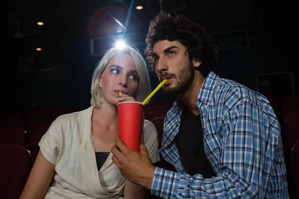 Pareja tomando bebidas mientras ve la película — Foto de Stock