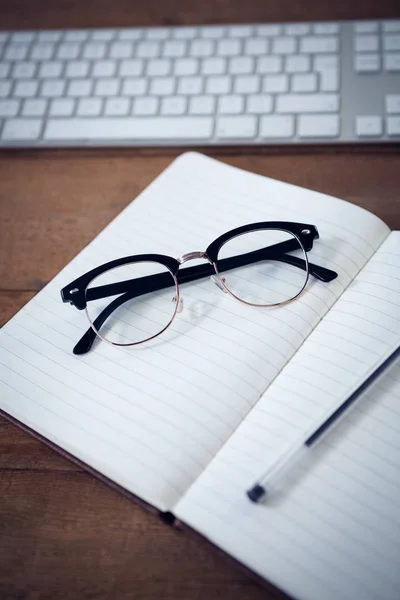 Dagboek met pen en brillen door toetsenbord — Stockfoto