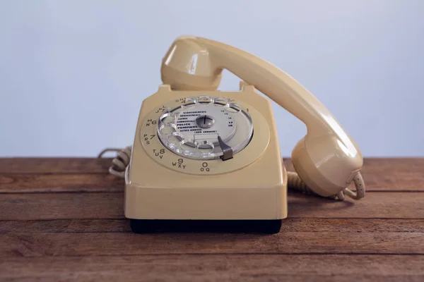 Винтажный телефон на деревянном столе — стоковое фото