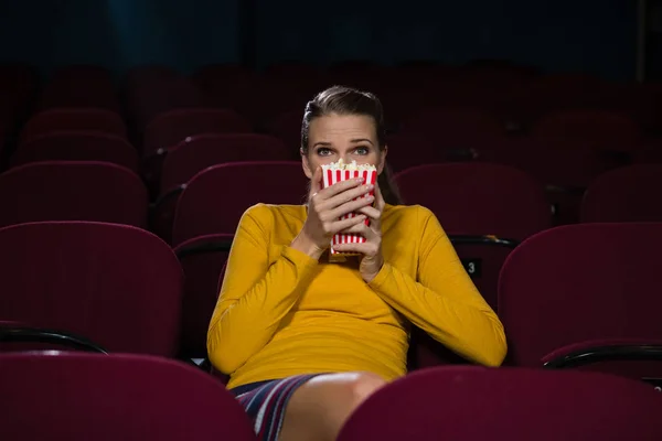 Woman scared while watching movie — Stock Photo, Image