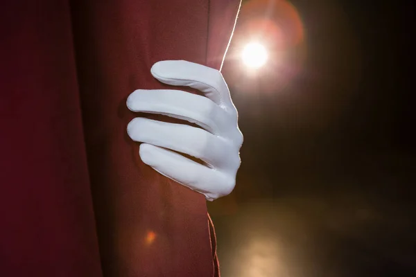 Mano en un guante blanco tirando de la cortina — Foto de Stock
