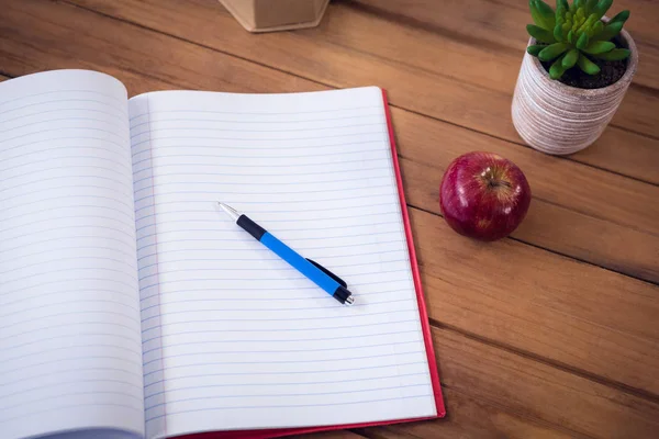 Libro con penna e mela di pianta d'appartamento — Foto Stock