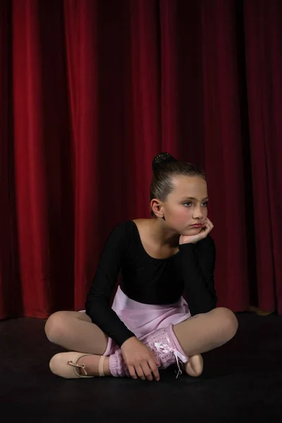 Балерина сидит на сцене в театре — стоковое фото