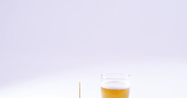 Hambúrguer e copo de cerveja contra fundo branco — Vídeo de Stock