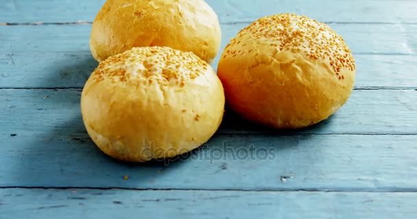 Verschillende Hamburger broodjes gerangschikt op houten tafel — Stockvideo