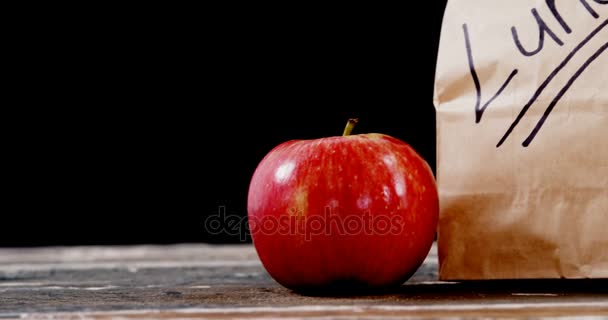 Manzana y paquete en la mesa — Vídeos de Stock