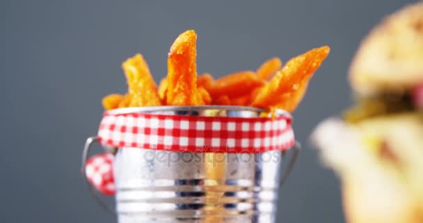 Hamburgare och pommes frites mot grå bakgrund — Stockvideo