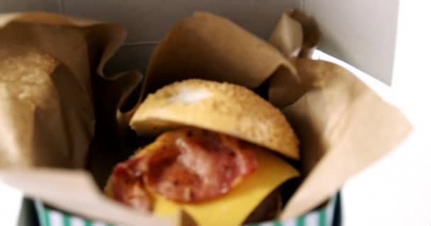 Hamburger w take away pojemnik na stole — Wideo stockowe