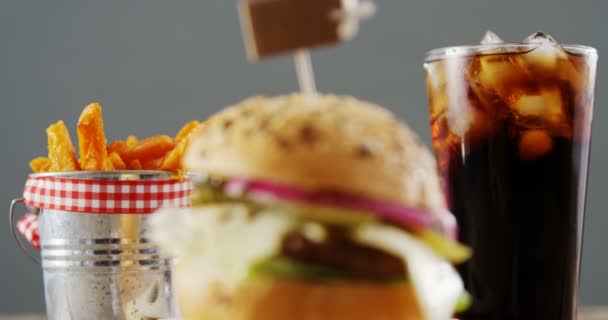 Гамбургер, картошка фри и холодные напитки на столе — стоковое видео