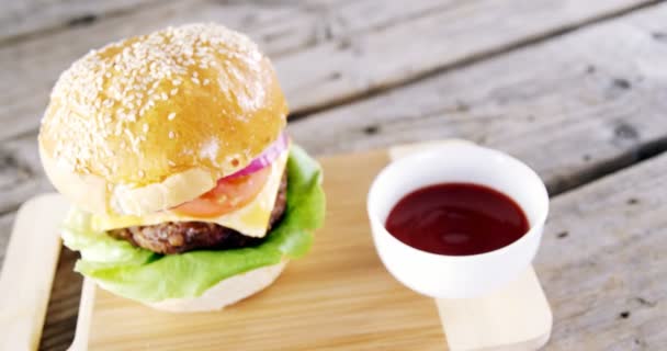 Hamburger and tomato sauce on chopping board — Stock Video