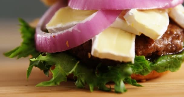 Hamburguesa sobre tabla de madera — Vídeo de stock