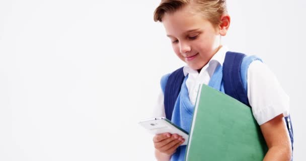 Школьник с мобильным телефоном на белом фоне — стоковое видео