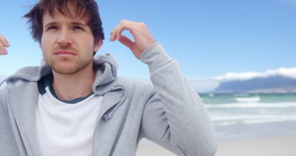 Hombre con capucha en la playa — Vídeo de stock