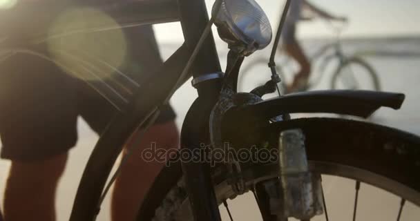 Hombre de pie con su bicicleta en la playa — Vídeos de Stock