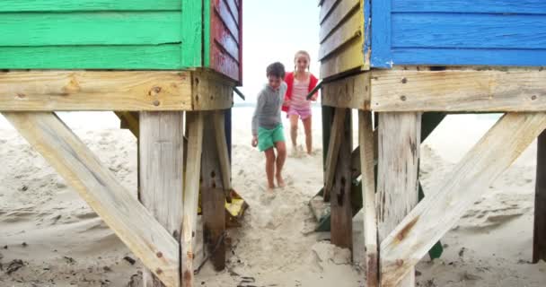 Niños corriendo por la cabaña de la playa — Vídeo de stock