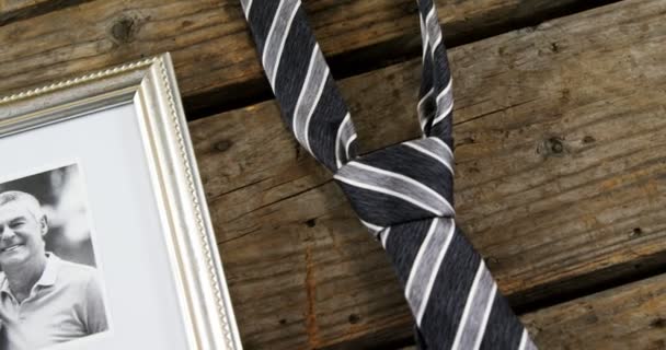 Photo frame and tie on wooden plank — Stock Video