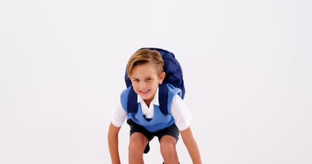 Sonriente colegial divirtiéndose contra fondo blanco — Vídeos de Stock