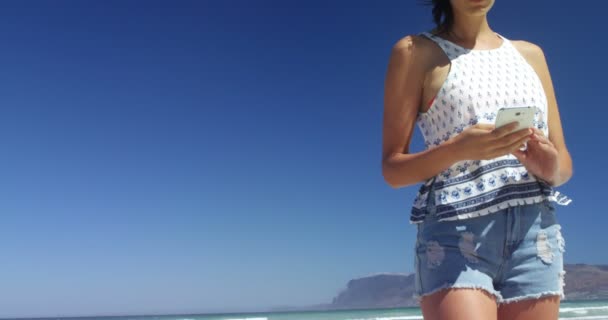 Красива жінка, використовуючи мобільний телефон на пляжі — стокове відео