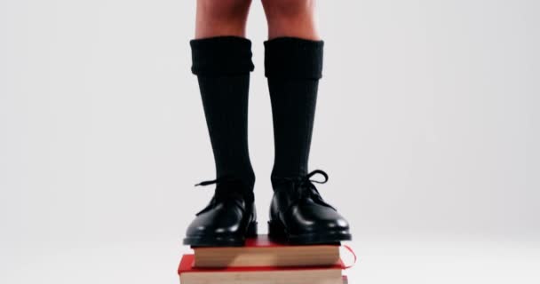 Возбужденный школьник, стоящий на стопке книг — стоковое видео