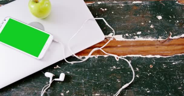 Мобильный телефон и зеленое яблоко на ноутбуке — стоковое видео