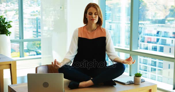 Mujer ejecutiva meditando en su escritorio — Vídeo de stock