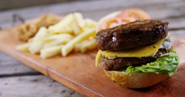 Queso derretido cayendo sobre hamburguesa en bandeja — Vídeos de Stock