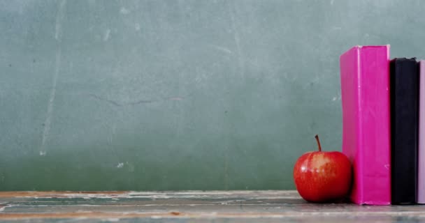 Apfel und Buch auf dem Tisch — Stockvideo