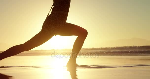 Силует жінки робить йогу на пляжі — стокове відео