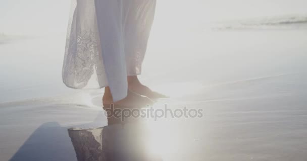 Žena stojící na pláži za slunečného dne — Stock video
