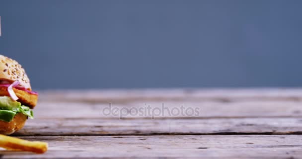 Hamburger e patatine fritte sul tavolo di legno — Video Stock