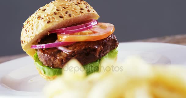 Гамбургер и картошка фри на тарелке — стоковое видео