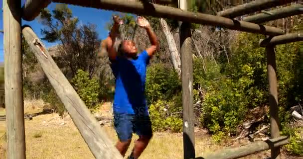 Determinado menino exercitando na barra de macaco — Vídeo de Stock