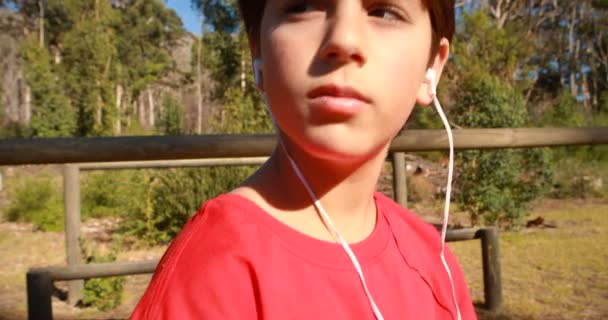 Niño escuchando música en el campamento de arranque — Vídeos de Stock