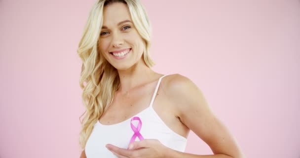 Woman showing breast cancer awareness ribbon — Stock Video