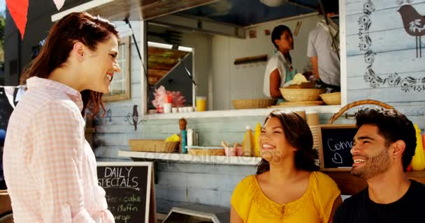 Amigos interactuando mientras comen bocadillos — Vídeos de Stock