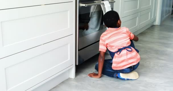 Chico curioso espiando en el horno y llamando a su padre — Vídeos de Stock
