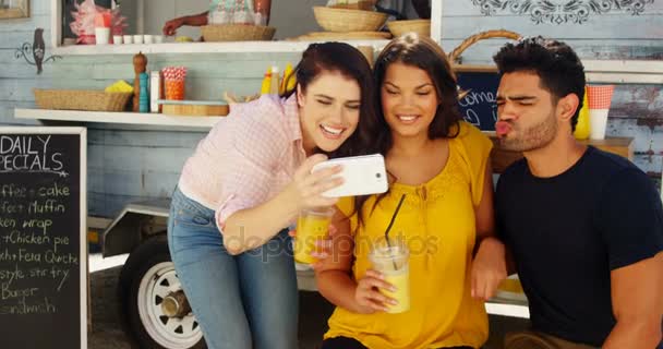 Amigos tomando selfie desde el teléfono móvil en camioneta de comida — Vídeos de Stock