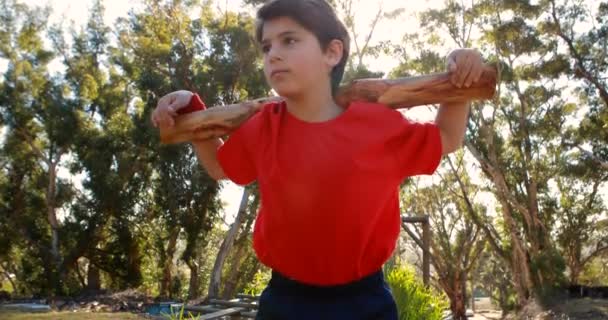 Niño haciendo ejercicio con registro en el campamento de arranque — Vídeos de Stock