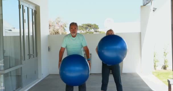 Seniorenpaar übt mit Gymnastikbällen — Stockvideo