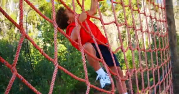 Junge klettert auf ein Netz — Stockvideo