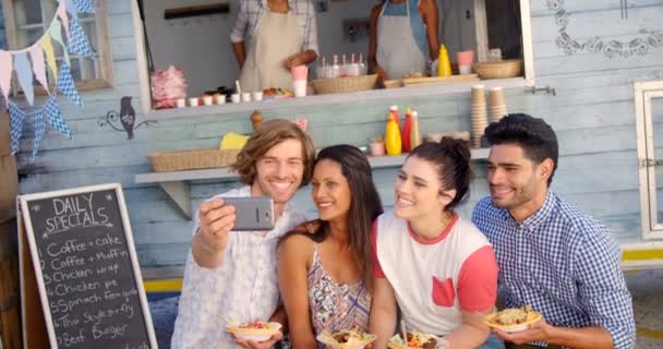 Amigos tomando selfie desde el teléfono móvil en camioneta de comida — Vídeo de stock