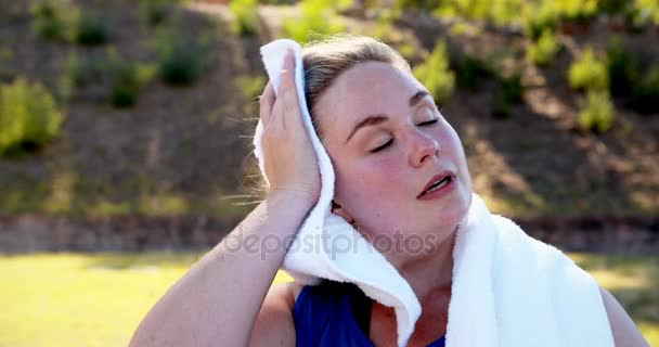 Mujer limpiando el sudor mientras bebe agua — Vídeos de Stock