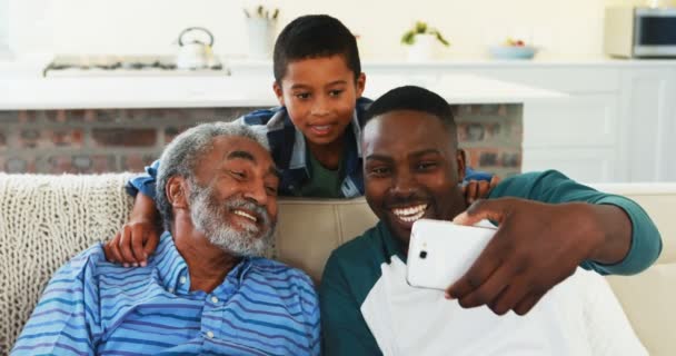 Family taking selfie from mobile phone in living room — Stock Video