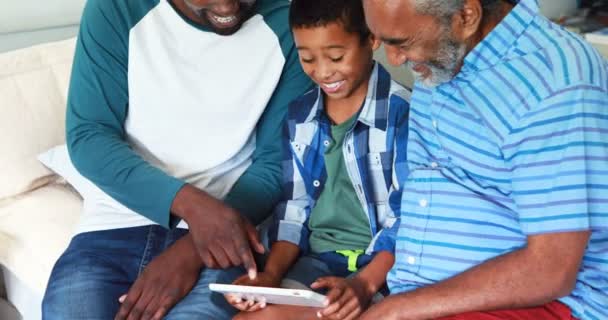 Семья из нескольких поколений, использующая цифровой планшет на кровати — стоковое видео