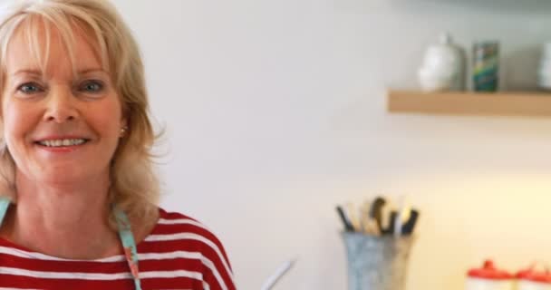 Portret van een lachende vrouw in de keuken — Stockvideo