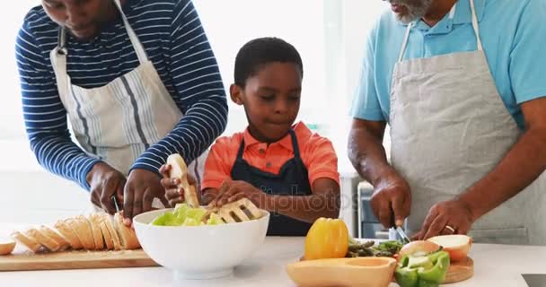 Niño preparando ensalada con su padre y abuelo — Vídeos de Stock