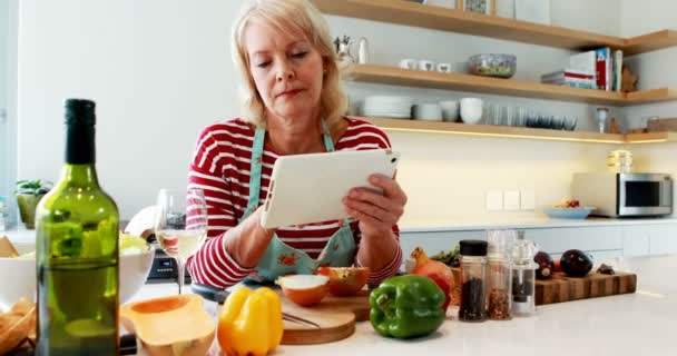 Frau nutzt digitales Tablet bei einem Glas Wein — Stockvideo